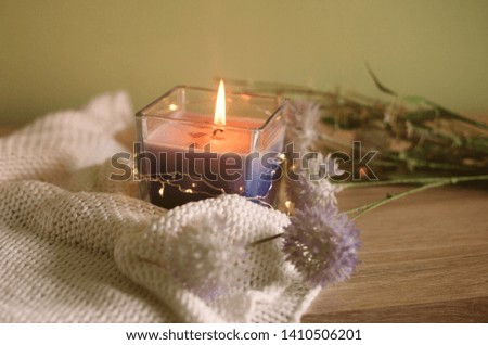Still life with book, wild flowers and candle on a wooden table. Decoration for cozy home interior.