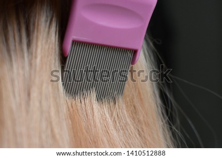 Combing blond hair with a lice comb