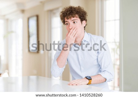 Young business man with curly read head bored yawning tired covering mouth with hand. Restless and sleepiness.