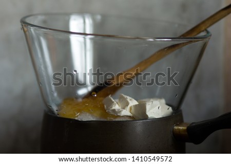 Making batter in the pot on simmerng water for russian honey cake Royalty-Free Stock Photo #1410549572