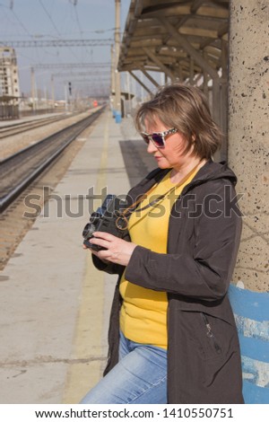 Girl with an old camera at the railway station.