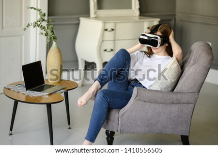 Young woman adjusting her VR headset and smiling while at home
