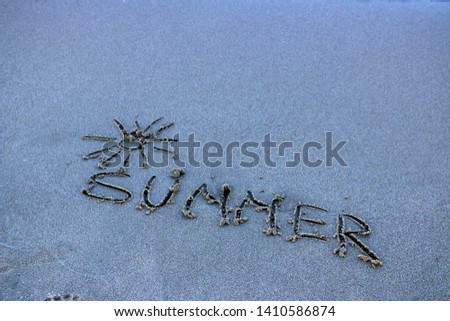 Summer Written in the Sand on a Beach with Sea in Background Royalty-Free Stock Photo #1410586874