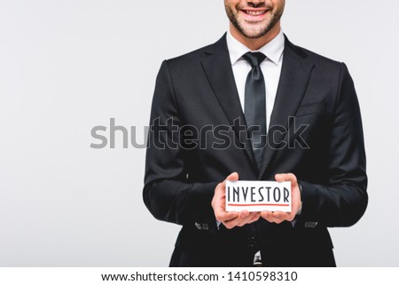 cropped view of businessman in suit hodding card with investor word isolated on grey