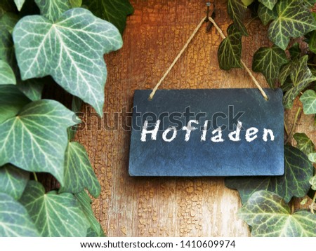 German: "Farmshop", board on old door with ivy