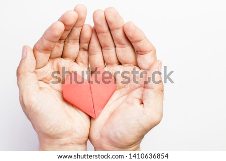 Hand with paper fold heart shape in palm, origami isolated on white background can be illustrated in article of symbol or language and communication or sign