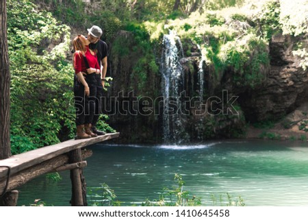 Male and woman, happy couples motorcyclists travelers. travel nature Forests, mountains, beautiful waterfall on background. summer day. vacation travel tour concept. Ukrane