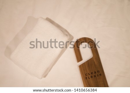 Towel and wooden tag label hanging sign of clean room for hotel, hostel, dormitory or accommodation doorknob with copy space