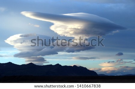 Lenticular clouds, Altocumulus lenticularis - amazing clouds on icelandic sky above mountains. Iceland Royalty-Free Stock Photo #1410667838