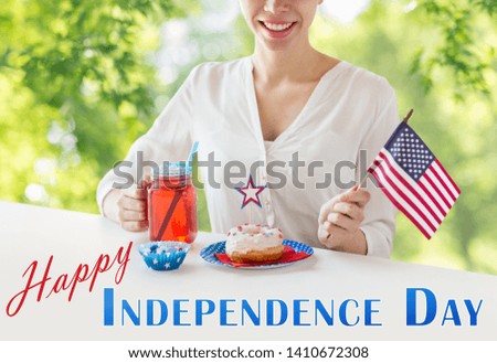independence day, celebration and holidays concept - close up of happy woman with donut celebrating 4th july, holding american flag and juice in glass mason jar or mug over green natural background
