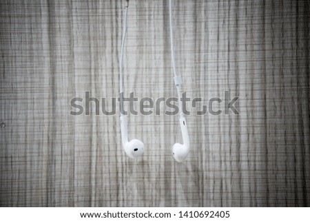 White earphone hanging on the wooden table