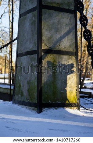 Massive column of the gate to the suspension bridge over Keila river, close to  Keila-Joa Castle Schloss Fall in the North-Western Estonia. Ghostly shadow of the German Shepherd dog on the post.