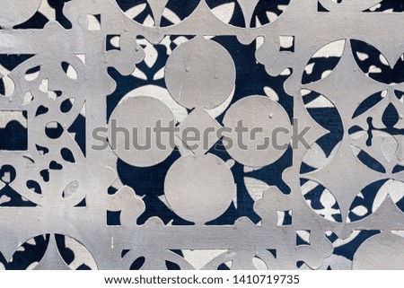 The structure of a gray metal plate with perforations in the form of circles of various shapes. Abstract background.