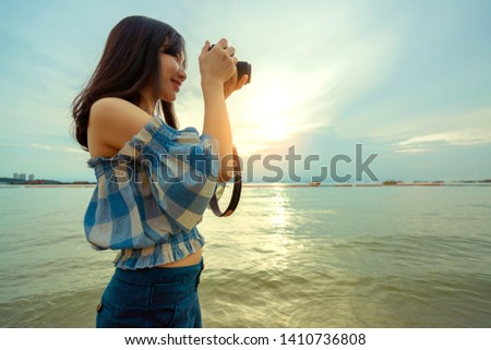 travel asian woman enjoy camera capture happiness moment on sunset beach twilight time