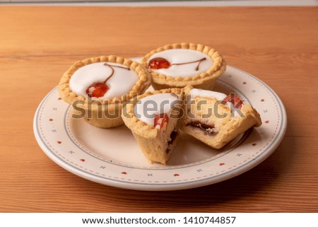 Cherry Bakewell tarts on a wooden background. 