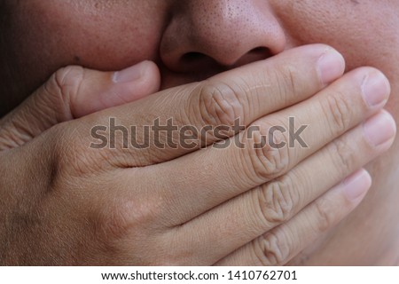 The face of a fat man is gagged in order to hide some secret, not wanting others to know. Royalty-Free Stock Photo #1410762701