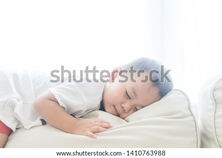 Toddler boy sleeping in sofa and dream.Asian 2 years old baby boy sleep on the sofa in living room.Sleep time,Comfortable, peaceful and growth hormone concept. 