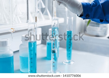 Analysis of the quality of liquids in a chemical laboratory, a device with equipment made of glass with a blue liquid