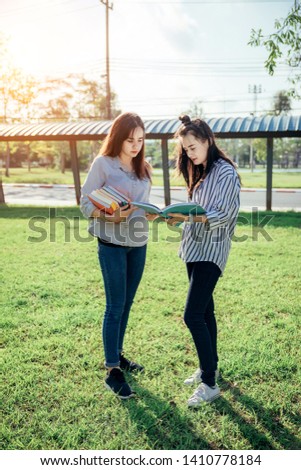 A group of teenage student in university smiling and reading the book in summer holiday.