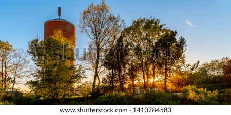 Sunset watertower tree sunlight array blue skies 