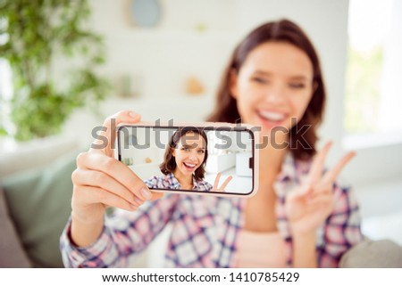 Close up photo of positive cheerful content lady excited millennial make v-signs video call live photos blog blogger good-looking joy style hair wavy curly checked shirt clothing cotton room