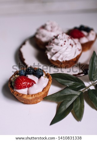 delicious dessert: berry tartlets with meringue. Sweet treat on white background.