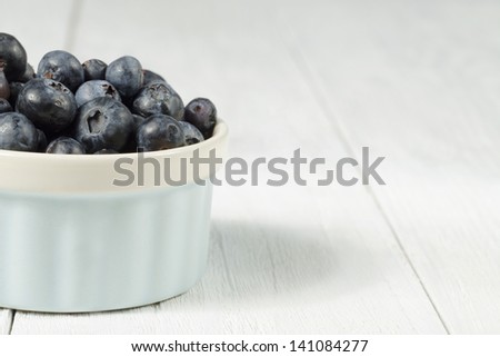 Bowl full of blueberries on wooden table