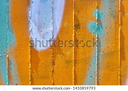 Colored abstract detail of a concrete wall in orange, white and blue.