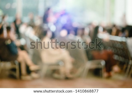 Blurry of auditorium for shareholders' meeting or seminar event, many business people listening on the conference. blurred background of many people.