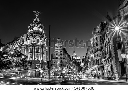 Rays of traffic lights on Gran via street, main shopping street in Madrid at night. Spain, Europe. Black and white photo.