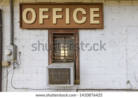 Large office sign on side of forgotten and abandoned building in the deep south