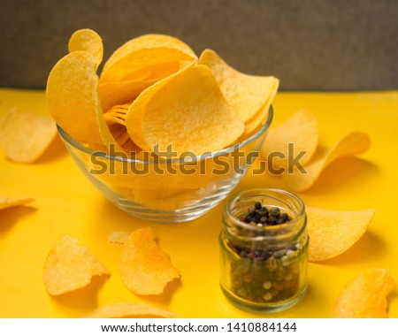 Crispy potato chips on yellow background, top view