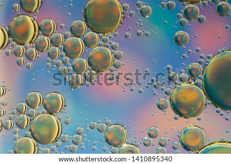 Blue and gold psychedelic abstract formed by oil droplets floating on water