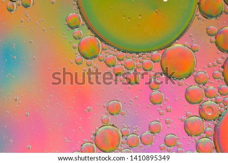 Pink psychedelic abstract formed by oil droplets floating on water