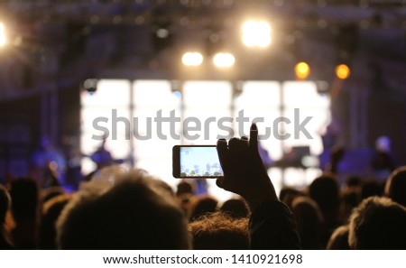 person records a video of the live concert with the modern smartphone