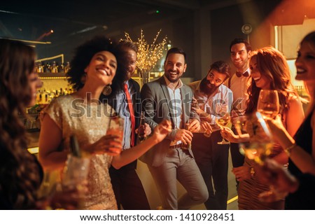 Group of friends celebrating with drinks Royalty-Free Stock Photo #1410928451