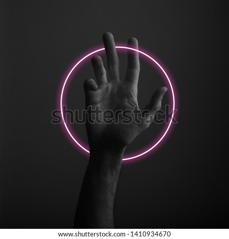 Male open hand gesture on a dark background with abstract neon light glow