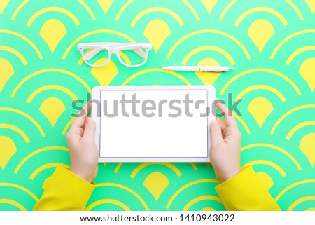 Man holds a tablet and looks at the screen. Mobile development. Innovational online businesses. Internet technologies. Trendy design. Geometry. Fashionable vibrant colors. Using a device. UX and UI.