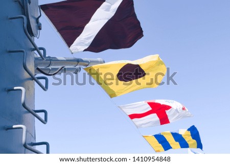 Maritime flags posted on the warship hoardings on a holiday in a random order that does not constitute a message.