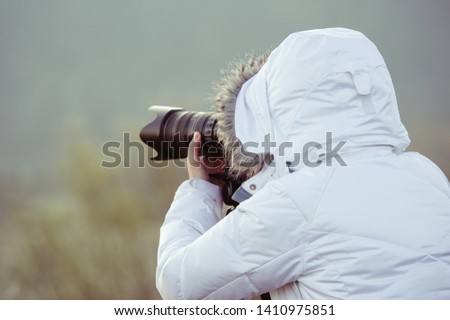 photographer with camera and tripod outdoor making landscape picture