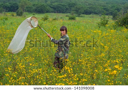 The entomologist with butterfly-net on meadow.