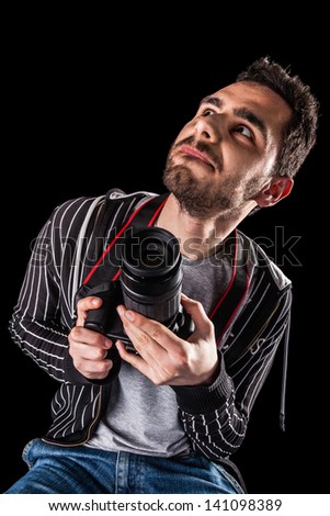 an handsome photographer with a dslr isolated on a black background