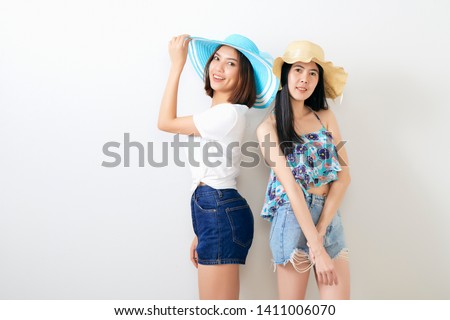 Multiethnic attractive joyful and carefree girls clothed in casual summer wear shooting at studio bright gray background with copy space. Woman Apparel. Friendship day, Tropical tourism concept