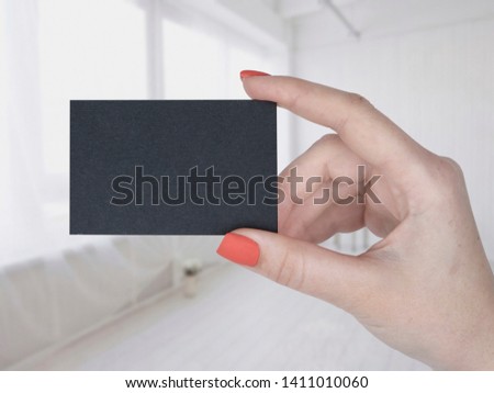 A woman holding a black business card