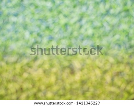The blurry pictures of Artificial turf making it green and yellow color using as a background or wallpaper.