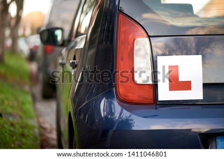 Laerner driver 'L' sign at the back of a blue hatchback compact car Royalty-Free Stock Photo #1411046801