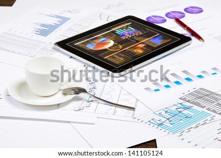 Image of cup of coffee and ipad laying on business documents