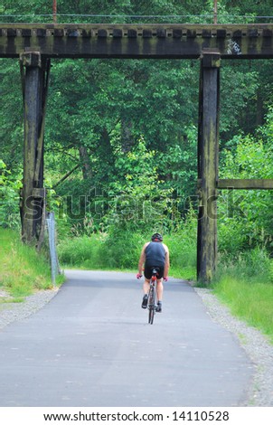 Man riding a bike on a trail outdoors.