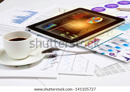 Image of cup of coffee and ipad laying on business documents