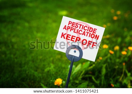 Pesticide applicaton sign with treated grass and dandelion weeds